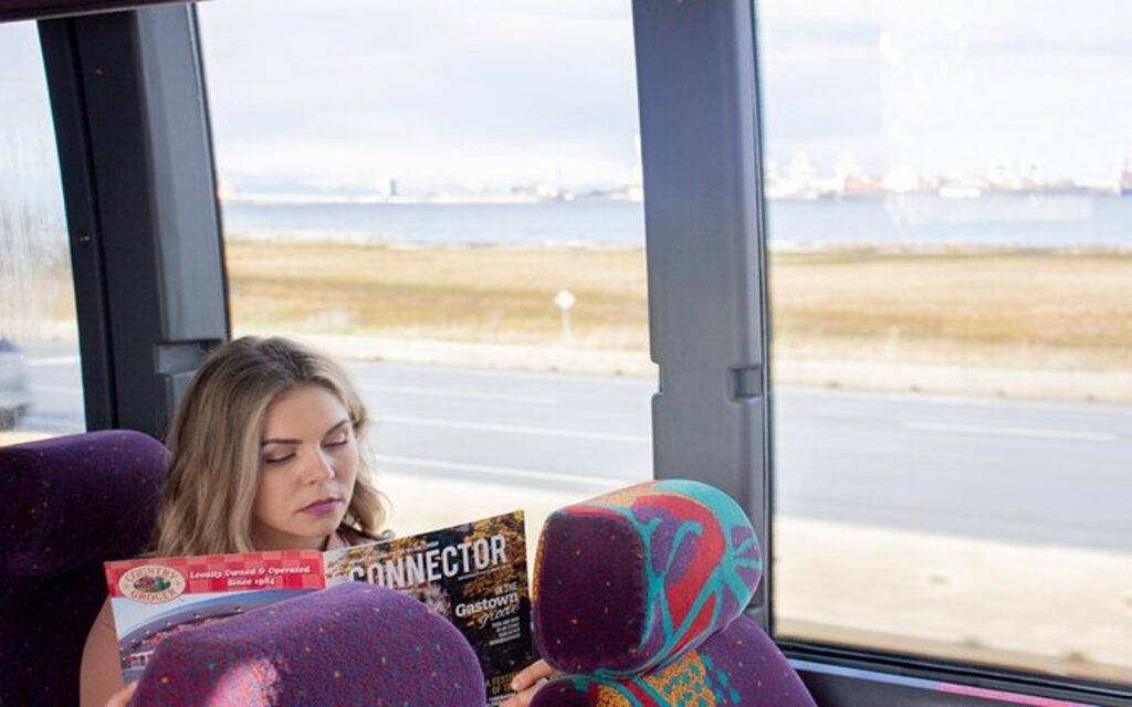 a woman enjoys her trip aboard the vancover airport to victoria bus