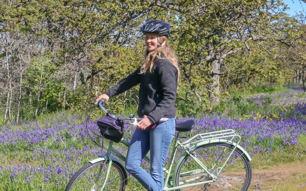 a woman bikes through Victoria's Beacon Hill Park.